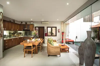 a kitchen and living room with a table and chairs at Villa Rendezvous Bali in Seminyak