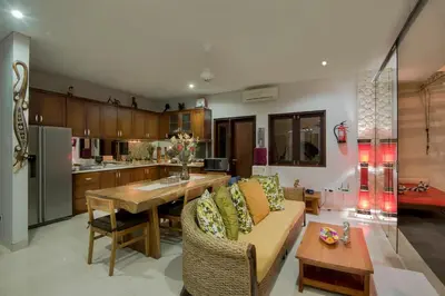 a kitchen and living room with a couch and a table at Villa Rendezvous Bali in Seminyak