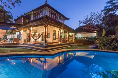 a house with a swimming pool in front of a house at Villa Blue - 4BR authentic and atypical villa in Seminyak in Seminyak