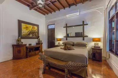 a bedroom with a bed and a table and a mirror at Villa Blue - 4BR authentic and atypical villa in Seminyak in Seminyak