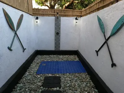 a shower with two paddles on the side of a wall at Villa Blue - 4BR authentic and atypical villa in Seminyak in Seminyak