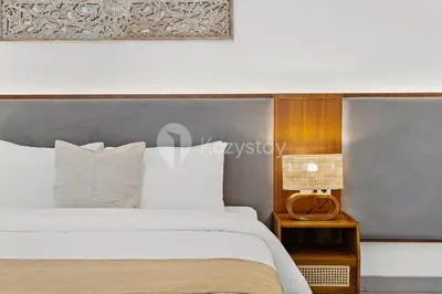 a bedroom with a large white bed and a lamp at Kros Villa by Kozystay - Legian in Legian