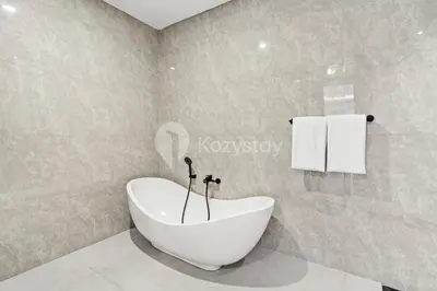 a bathroom with a white bath tub in a room at Kros Villa by Kozystay - Legian in Legian