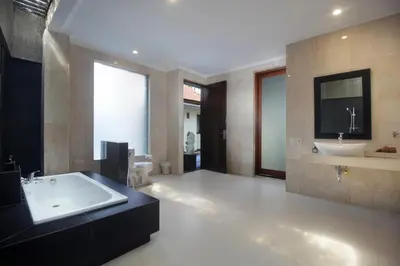 a large bathroom with a tub and a sink at Jayani Villa Seminyak byFaba in Seminyak