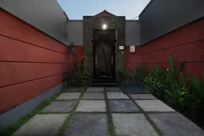 a hallway with a red wall and a door at Jayani Villa Seminyak byFaba in Seminyak