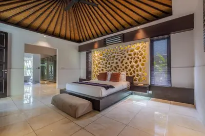 a bedroom with a bed and a large window at Villa Samudra Raya in Seminyak
