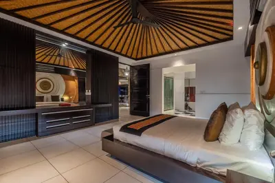 a bedroom with a large bed with a wooden ceiling at Villa Samudra Raya in Seminyak