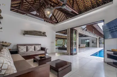 an open living room with a couch and a table at Villa Samudra Raya in Seminyak