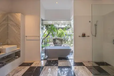 a bathroom with a tub and a shower and a sink at Villa Samudra Raya in Seminyak