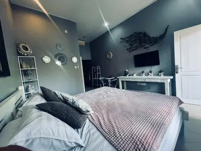 a bedroom with a bed and a tv on the wall at Gladstudio in Kerobokan