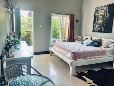 a bedroom with a large bed with a statue on the wall at Gladstudio in Kerobokan