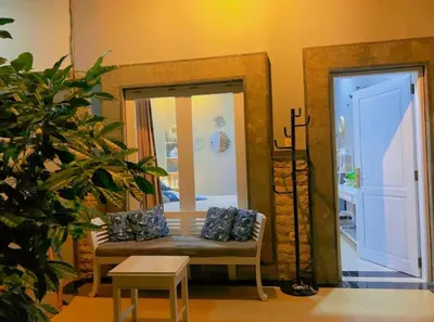 a living room with a couch and a mirror at Gladstudio in Kerobokan