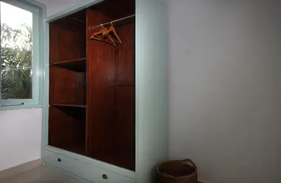 a wooden cabinet in a room with a window at Zowa Villa Seminyak byFaba in Seminyak