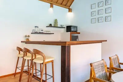 a bar in a room with chairs and a table at Villa Marsin Umalas - 10 Minutes to Finns Beach Club in Seminyak