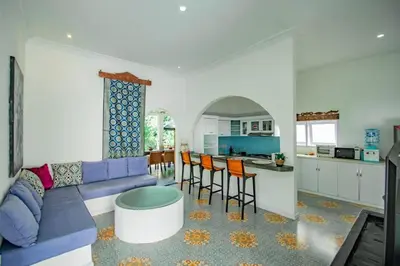 a living room with a blue couch and a kitchen at villa putih in Seminyak
