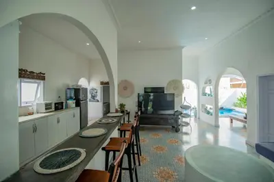 a kitchen with a long table and chairs in a room at villa putih in Seminyak