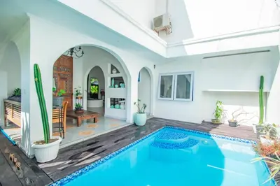 a swimming pool in a living room with a house at villa putih in Seminyak