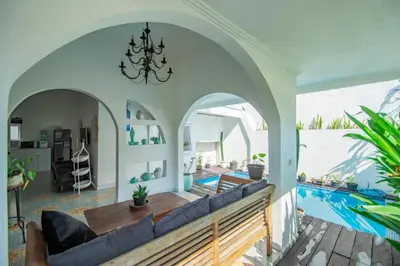 a living room with a couch and a swimming pool at villa putih in Seminyak
