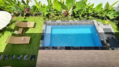 an overhead view of a swimming pool with chairs and a lawn at Villa Bumbabu in Kerobokan