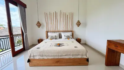 a bedroom with a bed and a large window at Villa Bumbabu in Kerobokan