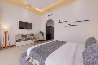 a bedroom with a large bed and a tv in it at Villa Phoenix Brand New 1BR in Umalas, Bali in Seminyak
