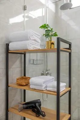 a shelf with towels and a hair dryer in a bathroom at Villa Phoenix Brand New 1BR in Umalas, Bali in Seminyak