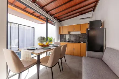 a kitchen with a table and chairs and a refrigerator at Villa Phoenix Brand New 1BR in Umalas, Bali in Seminyak