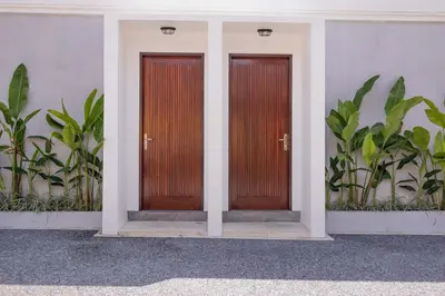 two wooden doors on the side of a building at Villa Phoenix Brand New 1BR in Umalas, Bali in Seminyak