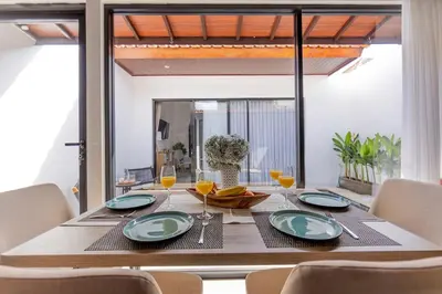 a dining room table with plates and glasses on it at Villa Phoenix Brand New 1BR in Umalas, Bali in Seminyak