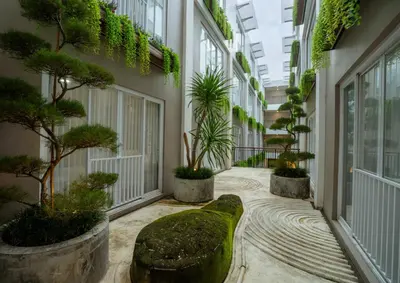 a hallway with trees and plants in a building at Grand Inkuta in Seminyak