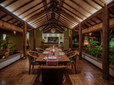 a dining room with a wooden table and chairs at Villa Mata Budha Seminyak in Seminyak