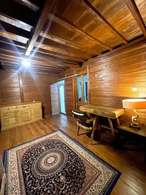 an empty room with a piano and a rug at 2BR Abelle garden lumbung house in Kerobokan