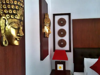 a bedroom with a bed and a lamp and a headboard at D'Mell Bali in Nusa Dua