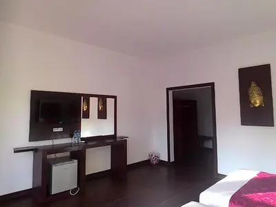 a bedroom with a bed and a flat screen tv at D'Mell Bali in Nusa Dua