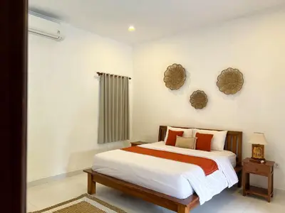 a bedroom with a bed and two mirrors on the wall at 4bedroom - Kamaya Villa in center of Seminyak in Seminyak