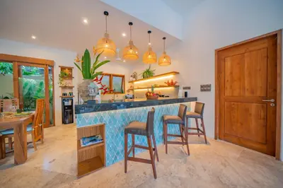 a kitchen with a bar with chairs and a table at Villa Lea Luxury Oasis in Seminyak Umalas with private pool 4BR in Seminyak