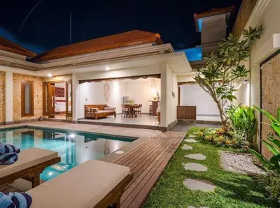 a house with a swimming pool and a living room at Metta Villa in Jimbaran