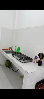 a kitchen counter with a stove and a sink at narayuka house kamar 3 in Seminyak
