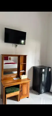 a room with a television and a desk with a tv at narayuka house kamar 3 in Seminyak