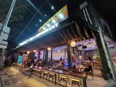a restaurant with people sitting at tables at night at Pepitu Dormitory By Sandat in Kuta