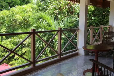 a wooden fence on a porch with a garden at Villa Varuna in Legian