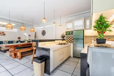 a large kitchen with a sink and a table at Villa Arbolita by JB Villas in Seminyak