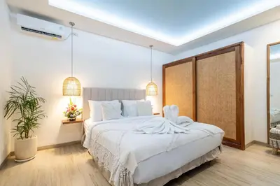 a bedroom with a large bed with white sheets at Villa Arbolita by JB Villas in Seminyak