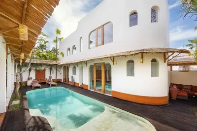 an exterior view of a house with a swimming pool at Villa Galanga - Brand New Ethnic Hacienda Villa Next to Canggu with Private Pool and Parking in Kerobokan