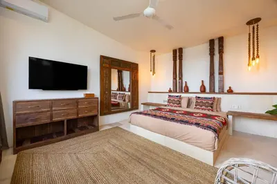a bedroom with a bed and a flat screen tv at Villa Galanga - Brand New Ethnic Hacienda Villa Next to Canggu with Private Pool and Parking in Kerobokan