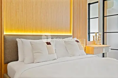 a bedroom with a large bed with white pillows at Palma by Kozystay - Nusa Dua in Nusa Dua