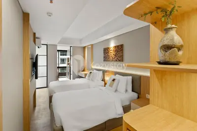 a hotel room with two beds and a table at Palma by Kozystay - Nusa Dua in Nusa Dua