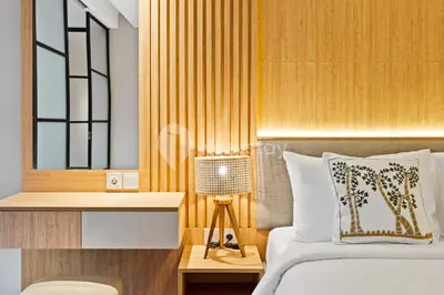 a bedroom with a bed and a table with a lamp at Olaia by Kozystay - Nusa Dua in Nusa Dua