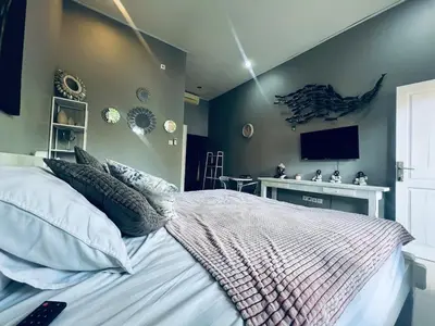 a bedroom with a bed and a tv on the wall at Gladstudio BrandNew in Kerobokan