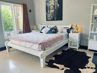 a bedroom with a white bed and a black rug at Gladstudio BrandNew in Kerobokan